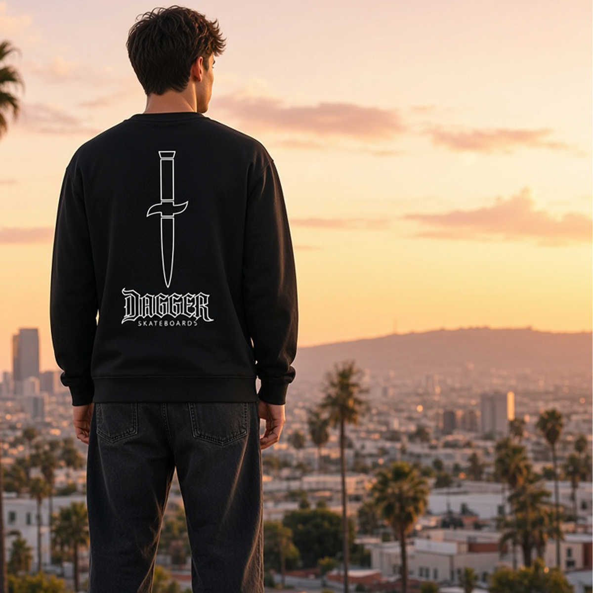 Model wearing black Dagger Outline Blade crewneck with white dagger back graphic at sunset