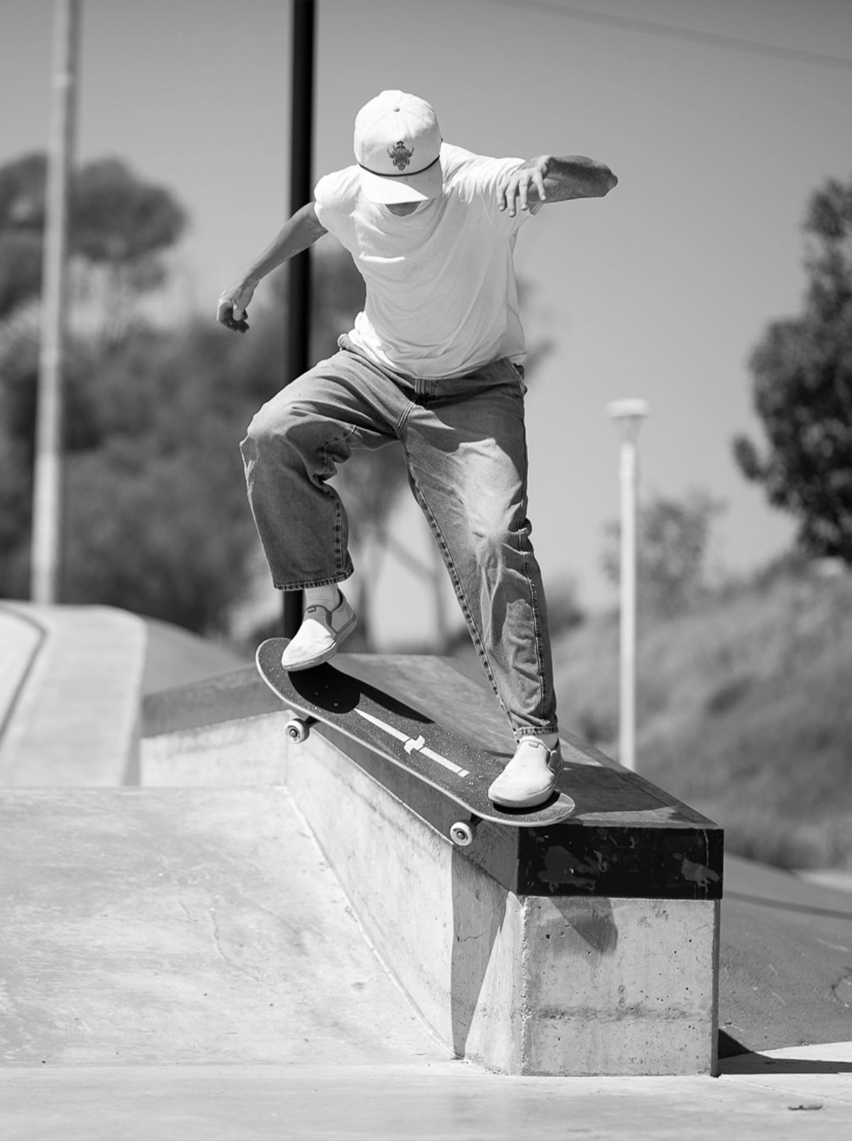 Skateboarder does a crook grind on a ledge at a concrete skatepark — Dagger Skateboards